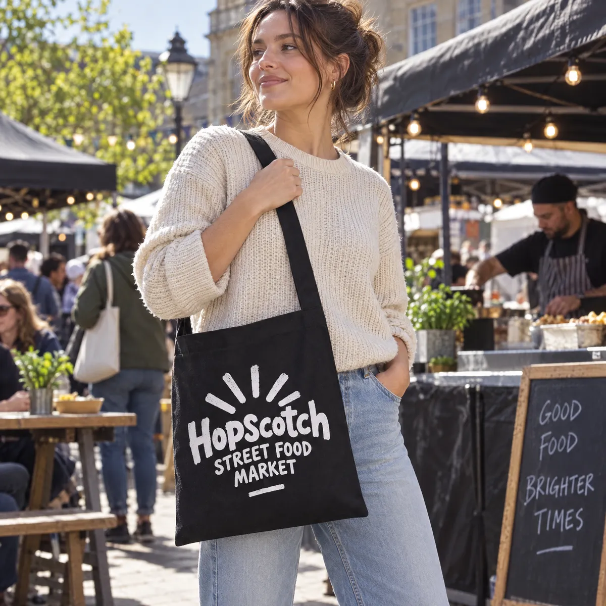 Woman wearing a black printed sling bag across her body at a food market