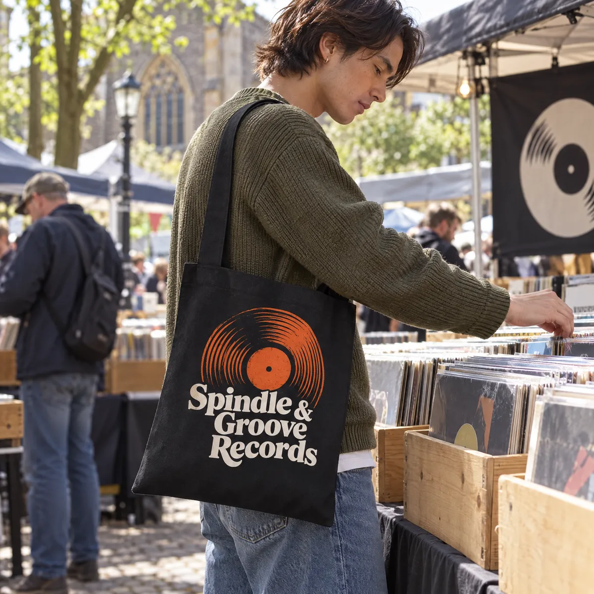Black cotton sling bag printed with a record shop logo, worn on one shoulder at a record fair