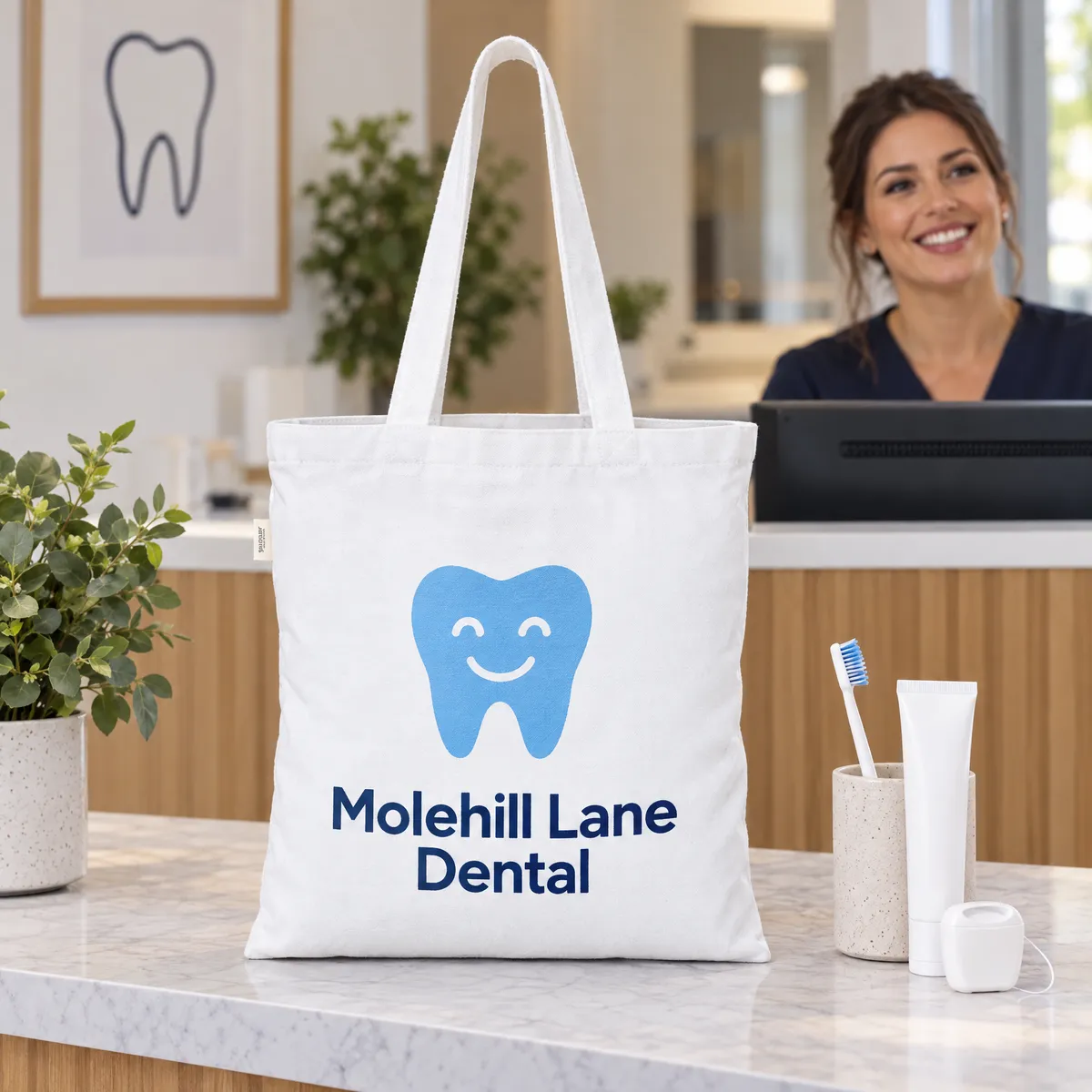 White tote bag printed with a smiling tooth logo on a dental practice reception desk