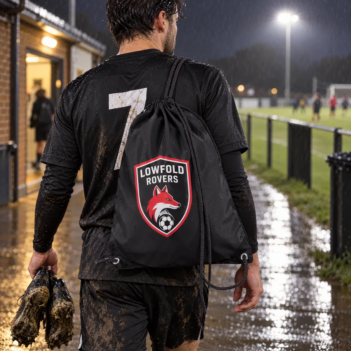 Black polyester drawstring bag printed with a Lowfold Rovers crest in red and white, carried off a floodlit pitch